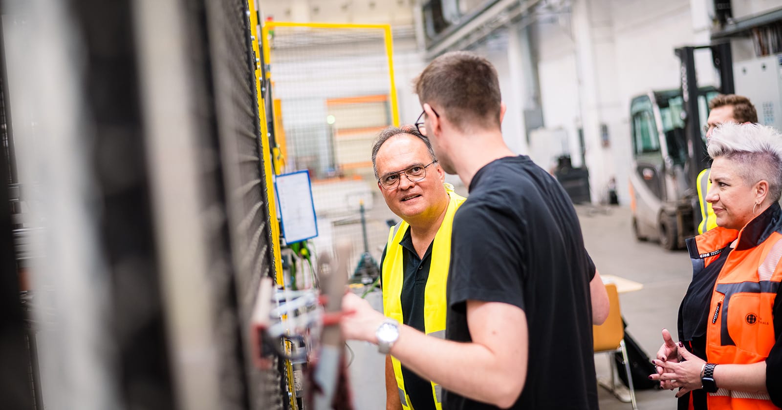 Mitarbeitende in Produktionshalle im Gespräch