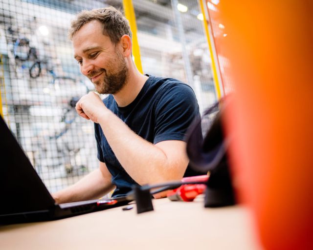 Solar Materials Mitarbeiter arbeitet am Laptop und lächelt